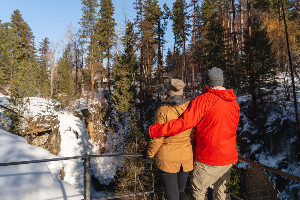 A couple viewing a frozen waterfall near Cranbrook, BC